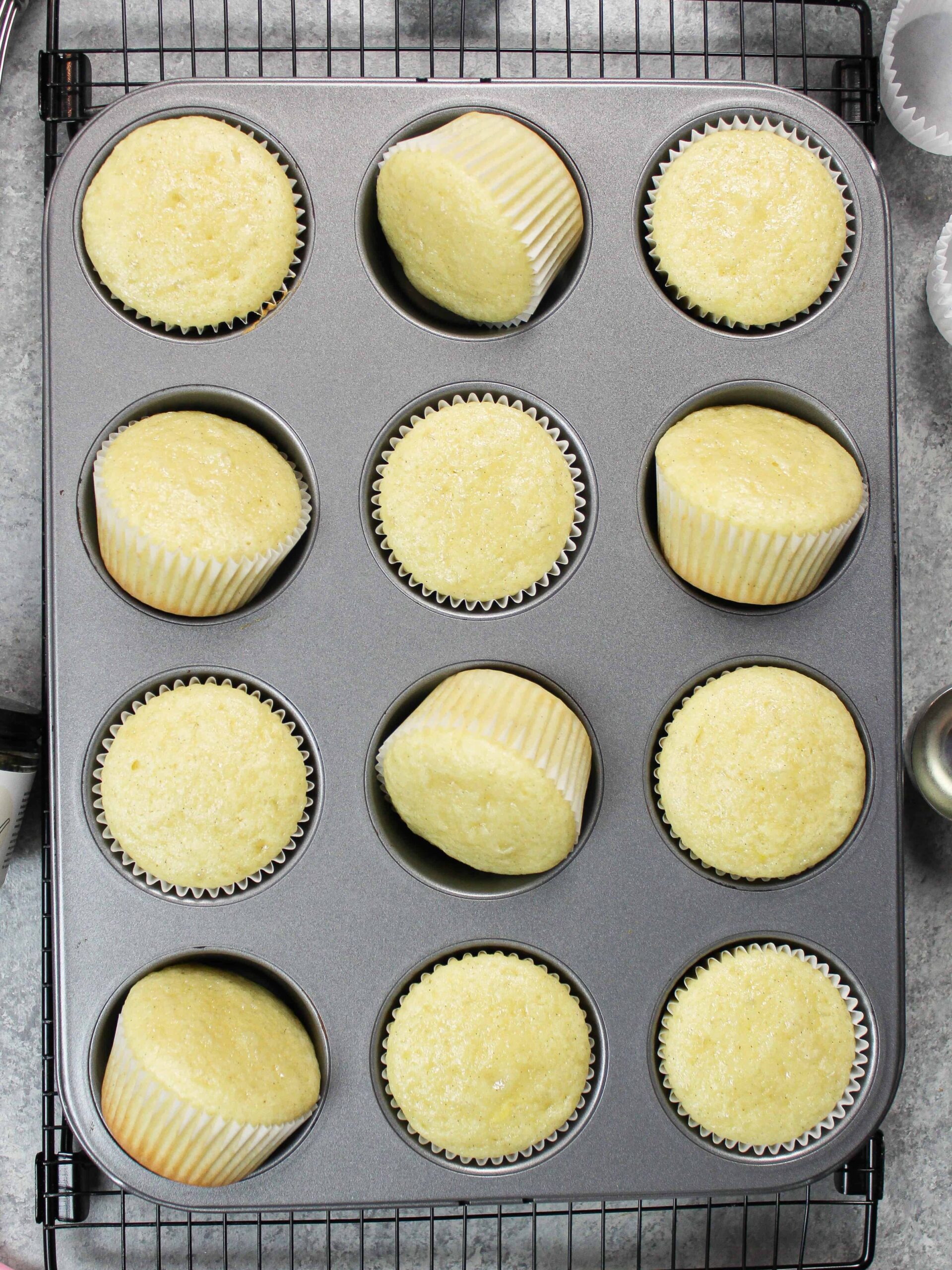 image of the moist vanilla cupcakes, made with oil and cooling in baking pan before being frosted