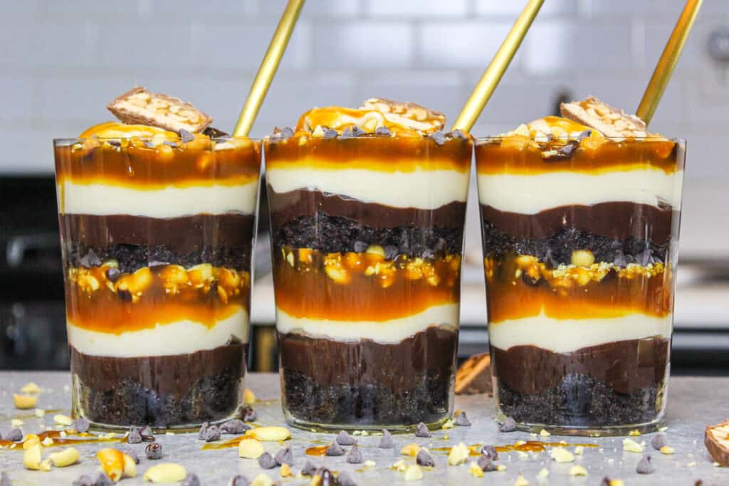 image of snickers trifles made in individual glasses to make them easy to serve and eat