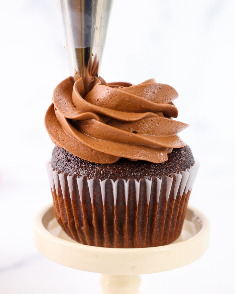 image of a chocolate cupcake being frosted with chocolate hazelnut buttercream