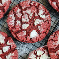 image of red velvet crinkle cookies cooling on a wire rack