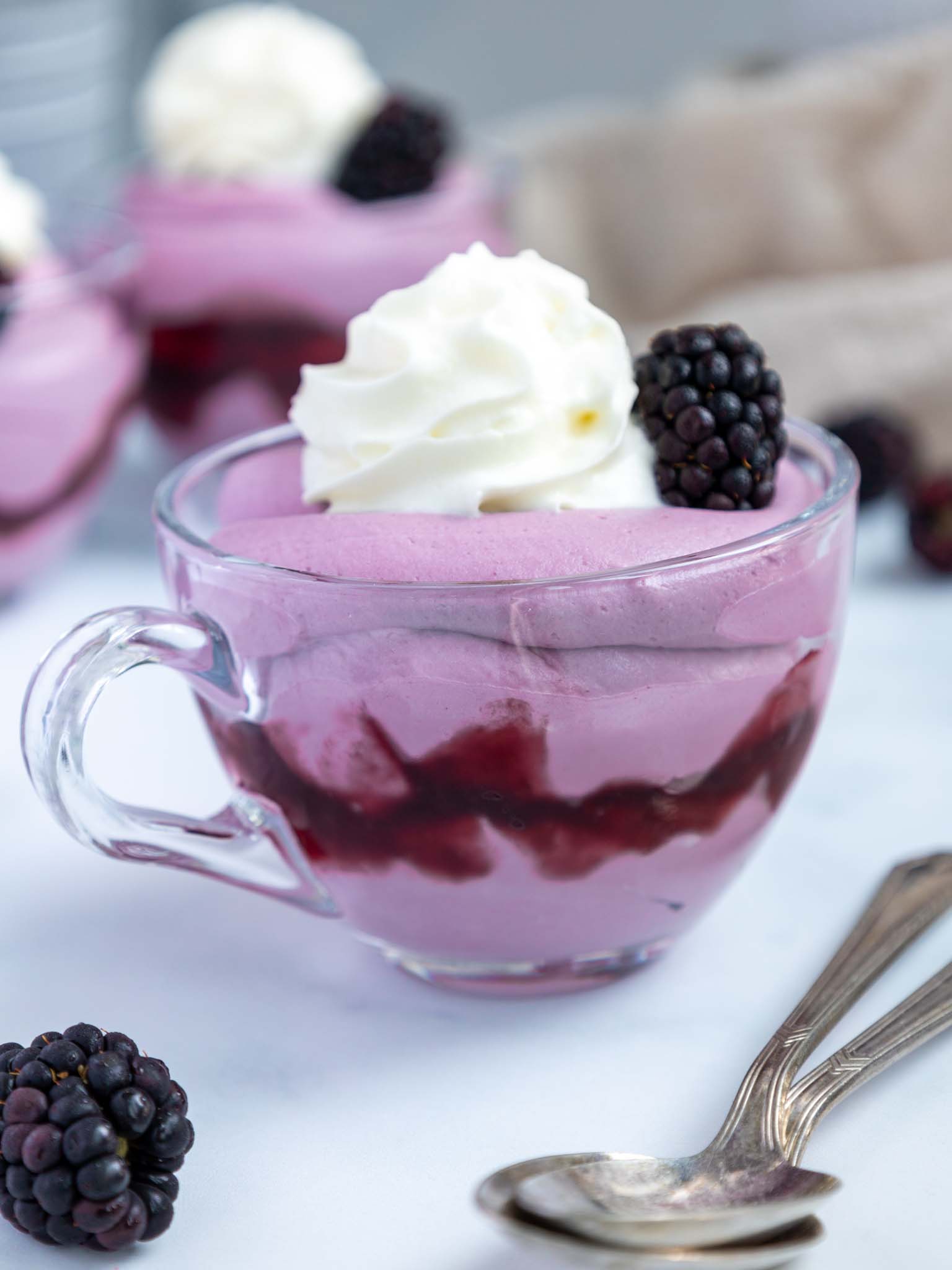 image of blackberry mousse in a cup topped with whipped cream